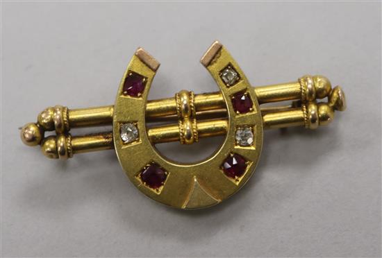 A late Victorian yellow metal, ruby and diamond set horseshoe twin bar brooch, 45mm.